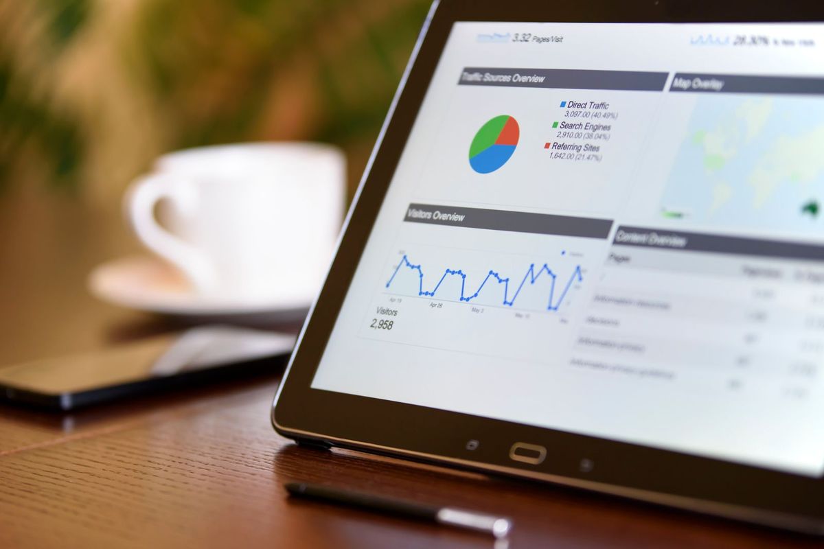 Tablet com painel de indicadores comerciais sobre mesa de trabalho