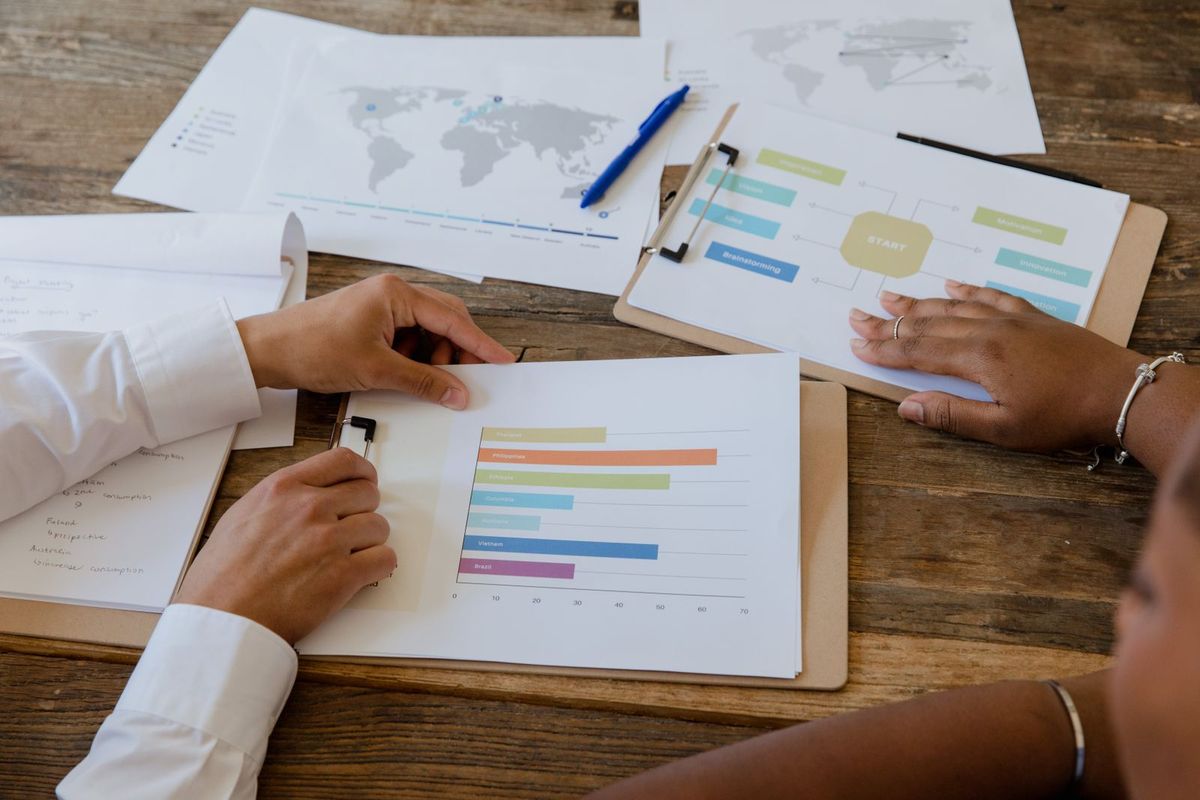 Mãos de executivos sobre relatórios impressos com gráficos de resultados