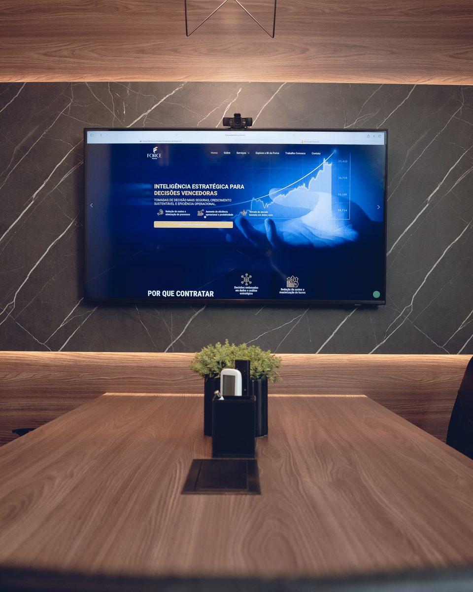 Sala de reunião da Force Partners com painel de indicadores na tela
